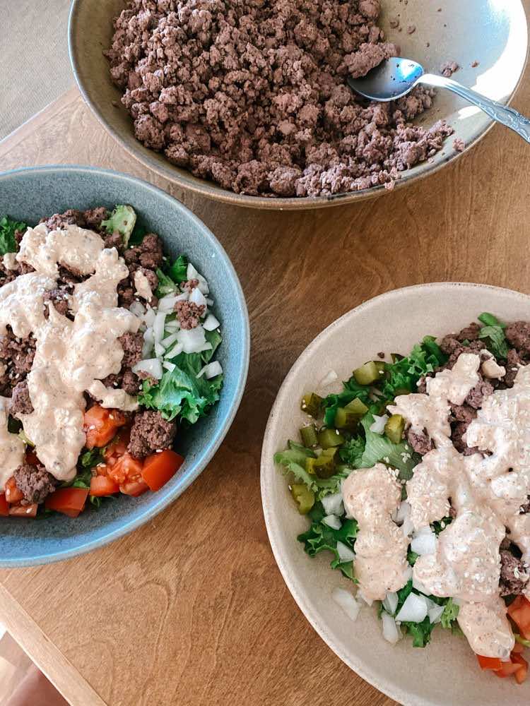 Deconstructed burger bowl with a creamy sauce.